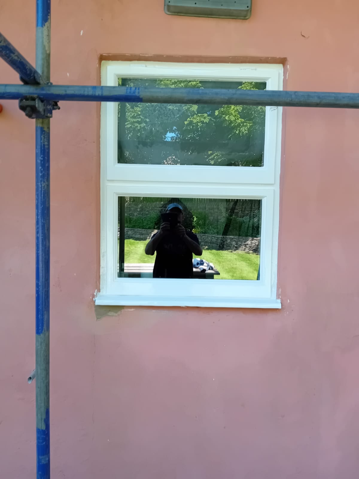 Casement window after restoration — freshly painted white frame on pink wall