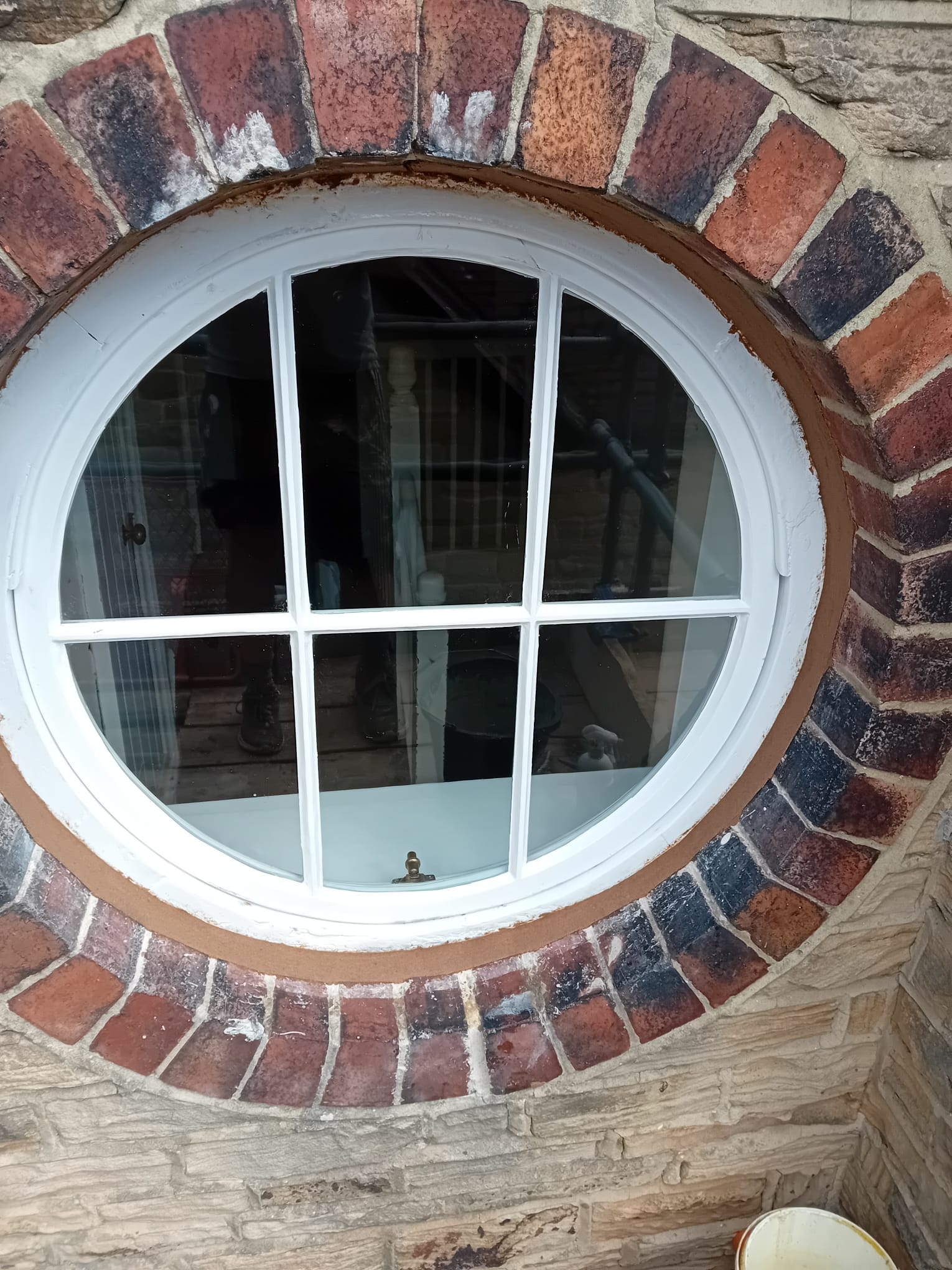 Circular window after restoration — fitted in red brick surround